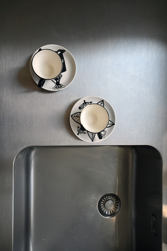 Stahl-Arbeitsplatte in der Küche, zwei Keramikbecher, Stahlspüle