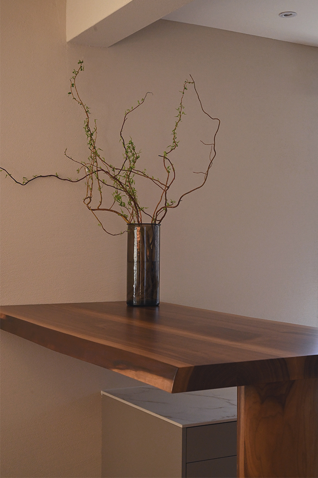 Deckenträger, massive Holzstange, Glas Vase, beige Wände, lange Äste